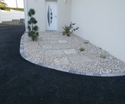 Aménagement entrée maison, avec dalles et massif cailloux